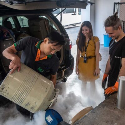 A group of three scientists at a mobile lab pouring liquid nitrogen onto samples